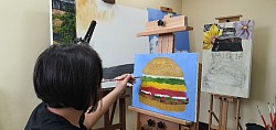 Zoe painting a hamburger.